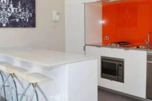 a kitchen with white cabinets and a microwave at One Bedroom Unit at Sydney Best Location in Sydney