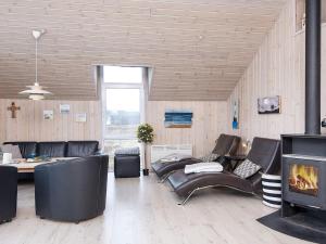 Holiday home Lemvig XII في ليمفج: غرفة معيشة مع أثاث من الجلد ومدفأة