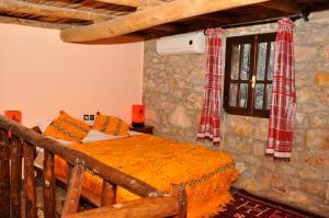 a bedroom with a bed in a stone wall at Auberge le Refuge in Agadir