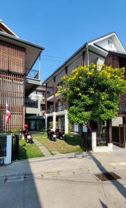 ein Gebäude mit einem Baum mit gelben Blumen darauf in der Unterkunft CHADA HOUSE in Chiang Mai