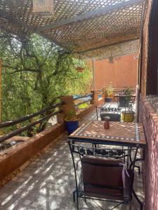 a patio with a table and chairs under a pergola at Auberge le Refuge in Agadir