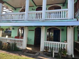 a house with a porch and a balcony at Hospedaje Rosa Del Mar in Big Corn Island