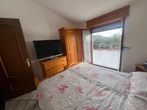 um quarto com uma cama e uma televisão de ecrã plano em Villa del sole em Magomadas