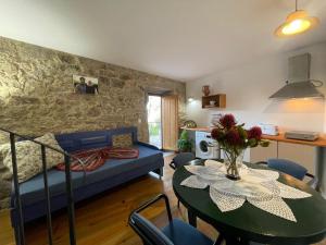 ein Wohnzimmer mit einem Tisch und einem Sofa in der Unterkunft AltaVista in Vitorino dos Piães