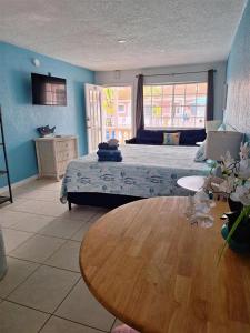 a bedroom with a bed and a wooden table at Blind Pass Resort Motel in St Pete Beach