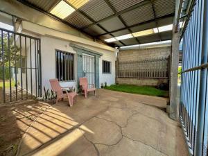 eine geschlossene Terrasse mit 2 Stühlen und einem Tisch in der Unterkunft Hidden Gem Nicaragua in Managua