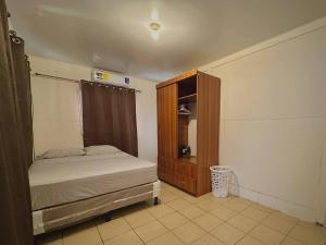 1 dormitorio con 1 cama y armario de madera en Hidden Gem Nicaragua en Managua