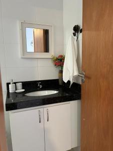 uma casa de banho com um lavatório e um espelho em Apartamento Por do sol Le Bon Vivant em Arraial do Cabo