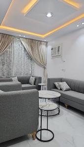 ein Wohnzimmer mit 2 Sofas und einem Tisch in der Unterkunft شاليهات الشموخ محايل عسير in Muhayil