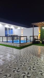 een huis met een patio en een zwembad in de nacht bij شاليهات الشموخ محايل عسير in Muhayil