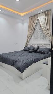 ein weißes Schlafzimmer mit einem großen Bett und einem Fenster in der Unterkunft شاليهات الشموخ محايل عسير in Muhayil