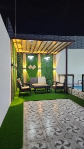 een patio met twee banken en een tafel op het gras bij شاليهات الشموخ محايل عسير in Muhayil