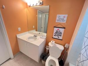 ein Badezimmer mit einem Waschbecken, einem WC und einem Spiegel in der Unterkunft Wynwood house Miami in Miami