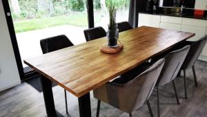een houten tafel in een keuken met stoelen eromheen bij Strand & Veluwemeer - Cube Elite Premium Bad Hoophuizen in Hulshorst