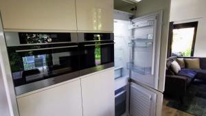 een keuken met een fornuis en een woonkamer bij Strand & Veluwemeer - Cube Elite Premium Bad Hoophuizen in Hulshorst