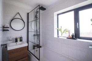 uma casa de banho com um chuveiro, um lavatório e um espelho. em Oasis in English Village em Crowthorne
