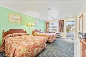 een hotelkamer met 2 bedden en een televisie bij Top Hill Motel in Saratoga Springs