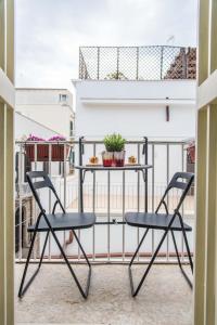 einen Tisch und zwei Stühle auf dem Balkon in der Unterkunft Porto Trani Maison D' Hòtes in Trani
