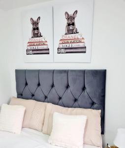 een bed met twee posters van een hond op een taart bij Modern Luxurious New Build Entire 2 Bedroom Apartment in Basildon