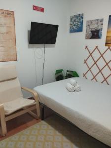 a bed and a chair in a room at Cozy Studio - 5 minutos a pé da praia in Costa da Caparica