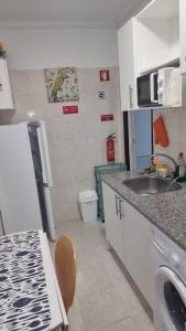 a small kitchen with a sink and a toilet at Cozy Studio - 5 minutos a pé da praia in Costa da Caparica