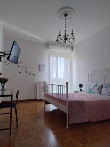 1 dormitorio con 1 cama, TV y lámpara de araña en La Casa di Giulia, en Ancona