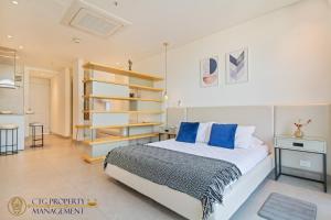 1 dormitorio con 1 cama grande con almohadas azules en Distrito 90 - Estudios y Apartamentos para vacaciones y viajes de negocio, en Barranquilla