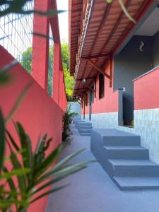 a building with stairs next to a red wall at Pousada Alves e Almeida in Cairu