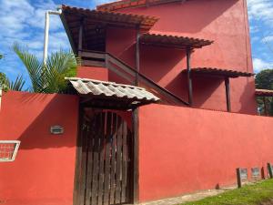 a red building with a gate on the side of it at Pousada Alves e Almeida in Cairu +2 photos