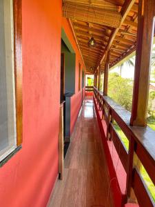 a corridor of a building with red walls and benches at Pousada Alves e Almeida in Cayru