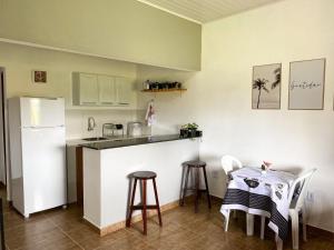 a kitchen with a table and a white refrigerator at Pousada Alves e Almeida in Cairu