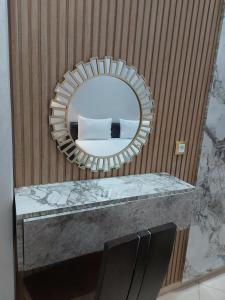 a mirror on a wall with a counter with a sink at borj rayhane 1 in Tangier