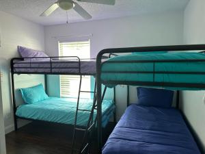two bunk beds in a room with a window at Adv. Coast: 4/2, Near Springs, Beach, Big Fenced Yard in Spring Hill