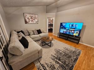a living room with a couch and a flat screen tv at Adv. Coast: 4/2, Near Springs, Beach, Big Fenced Yard in Spring Hill