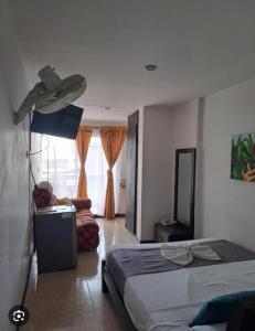 a bedroom with a bed and a lamp in it at Hotel Bolivariano AV in Ibagué