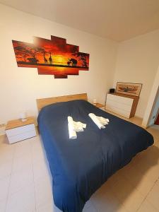 1 dormitorio con 1 cama azul y 2 almohadas en Lemon Tree House, en Ostia Antica
