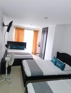 pokój hotelowy z 2 łóżkami i oknem w obiekcie Hotel Bolivariano AV w mieście Ibagué