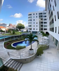 arial view of a building with a pool and a palm tree at Aptos no Luxor Tambaú próximo ao mar in João Pessoa