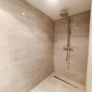 uma casa de banho com um chuveiro com azulejos bege em New Stylish Grand place City Center Duplex em Bruxelas