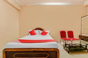 a bedroom with a bed and two red chairs at Sahasra Residency 43619 Near Nexus Hyderabad in Hyderabad