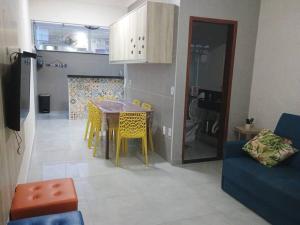 een keuken en een woonkamer met een tafel en stoelen bij Apartamento Ubatuba Condominio Maranduba Ville II in Ubatuba