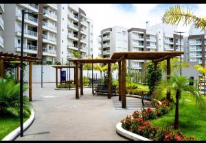 a park with benches and palm trees and buildings at Lagoa Eco Towers Resort in Caldas Novas