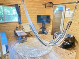那须町ペットと泊まれるロフト付建物｜CHILL SWING チビ的客厅设有吊床和电视。