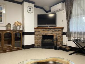 a living room with a tv on top of a fireplace at Koguriyama Sanso - Vacation STAY 37442v in Minami Uonuma