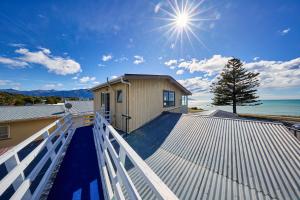 a house on top of a roof with the sun at Sea View Motel - Unit 1 in Kaikoura