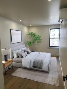 a bedroom with a large bed and a potted tree at Newly renovated massive three bedroom! in New York