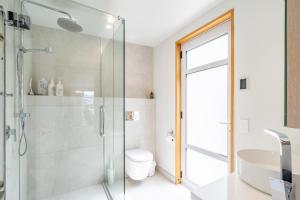 a bathroom with a glass shower stall and a toilet at Wanaka Entertainer in Wanaka