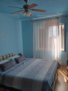 a blue bedroom with a bed with a ceiling fan at Apartments with a parking space Liznjan, Medulin - 11152 in Ližnjan