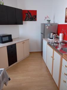 a small kitchen with white cabinets and a refrigerator at Apartments with a parking space Liznjan, Medulin - 11152 in Ližnjan