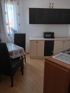 a kitchen with a table and two chairs and a counter at Apartments with a parking space Liznjan, Medulin - 11152 in Ližnjan